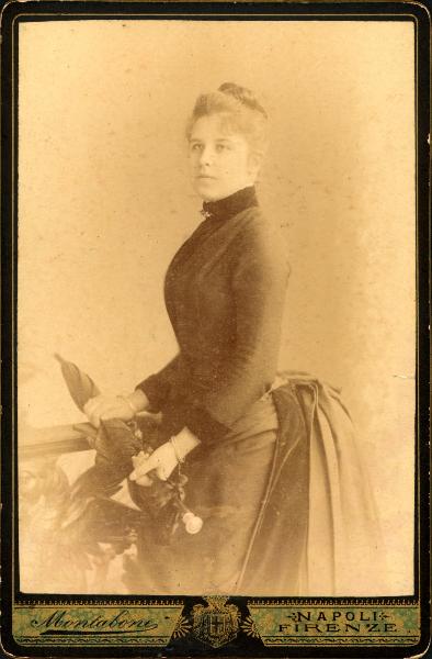 Ritratto femminile - Donna in piedi davanti a una balaustra con in mano un ombrellino da passeggio