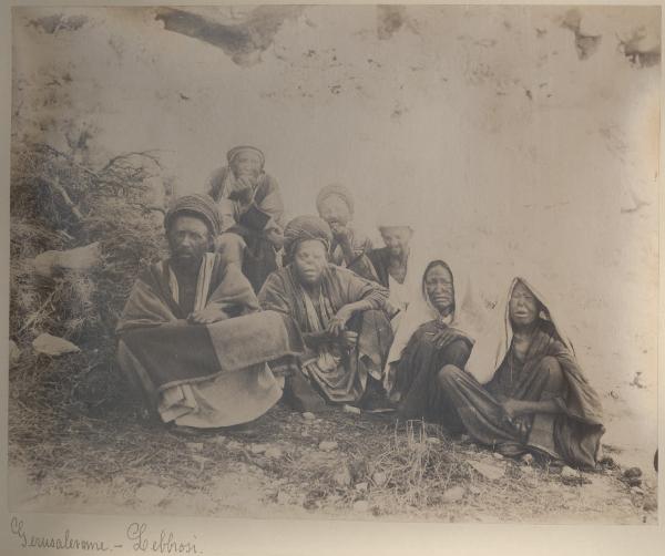 Palestina/Israele- Gerusalemme- Ritratto di gruppo - Cinque uomini e due donne seduti per terra - Lebbrosi