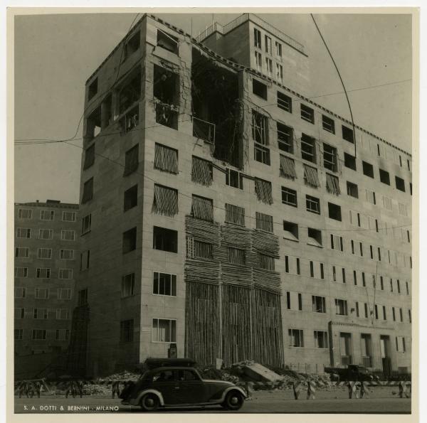 Milano - bombardamenti 1943 - Edificio della Montecatini colpito nella parte alta // Automobile in primo piano.