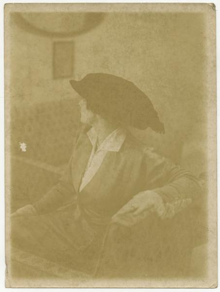 Ritratto femminile - Donna con cappello seduta su un divano - Interno