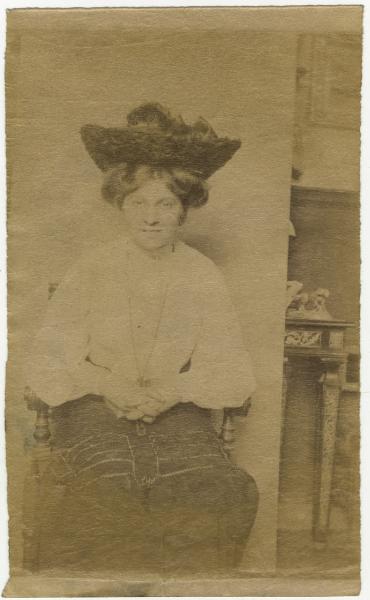Ritratto femminile - Donna con cappello seduta su una sedia - Interno, casa