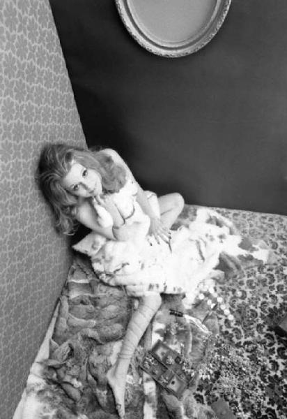 Ritratto femminile - giovane - modella nuda seduta in un bagno di gioielli che si copre con una pelliccia. Berit