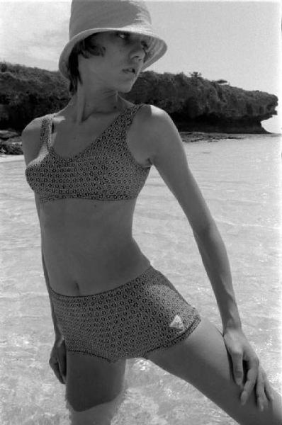 Ritratto femminile - modella indossa un bikini scuro, mare sullo sfondo