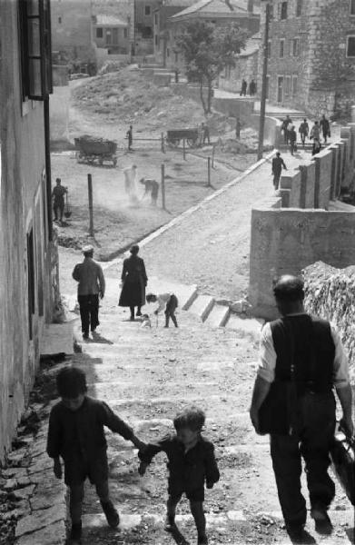 Viaggio in Jugoslavia. Sebenico: scorcio del borgo dalla cima di una strada in salita - in primo piano due fanciulli si tengono per mano