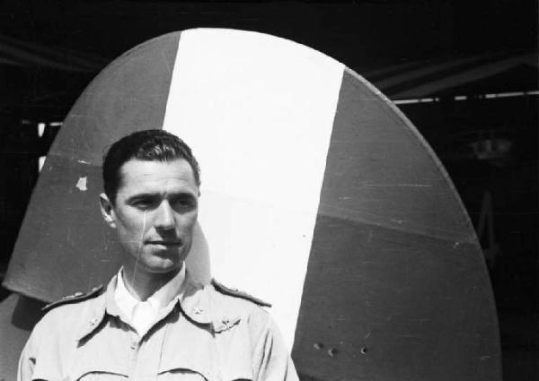 Viaggio in Africa. Ritratto maschile - il generale Pirzio Biroli posa davanti al timone di un areo dipinto con il tricolore