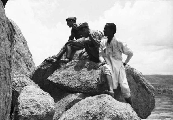 Viaggio in Africa. Sasso d'Utò - Due militari e un giovane indigeno tra le rocce