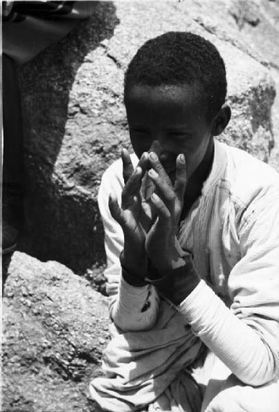 Viaggio in Africa. Sasso d'UtÃ² - Ritratto maschile - giovane indigeno posa tra le rocce