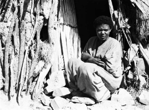 Viaggio in Africa. Ritratto femminile - donna indigena presso l'ingresso della sua capanna