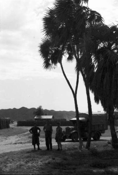 Viaggio in Africa. Archica [?] - pianura semidesertica - palme isolate - militari e autocarro