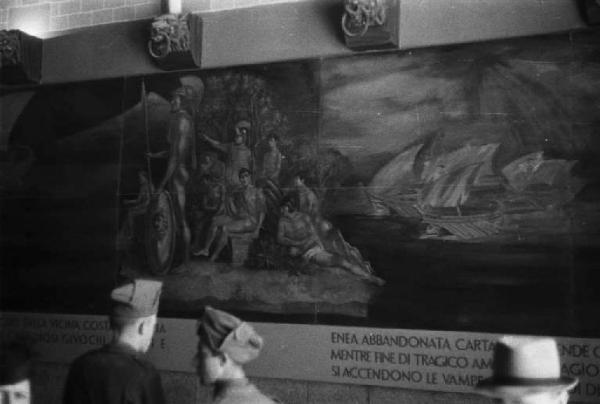 Prima Mostra Triennale delle Terre Italiane d'oltremare - padiglione Roma - sala 1 "Mito campano di Enea" - militari osservano un pannello raffigurante storie tratte dal mito di Enea