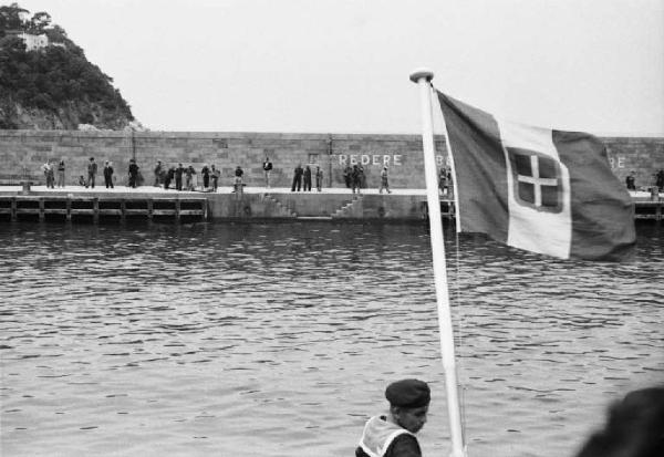 Porto di Capri. Persone sul molo - bandiera italiana