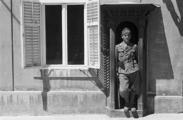 Viaggio in Jugoslavia. Zagabria: ritratto maschile, militare italiano in divisa posa sulla soglia di una casa