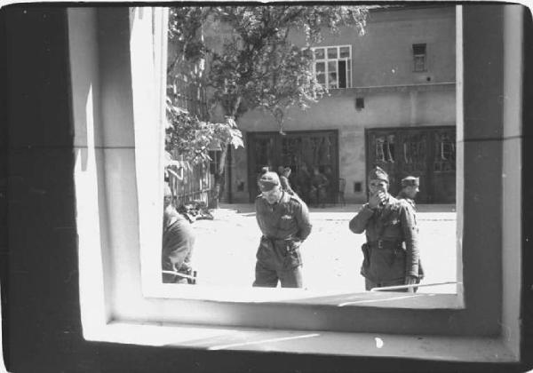 Viaggio in Jugoslavia. Zagabria: cortile della sede della polizia (?) e miliziani ustascia visti attraverso la finestra