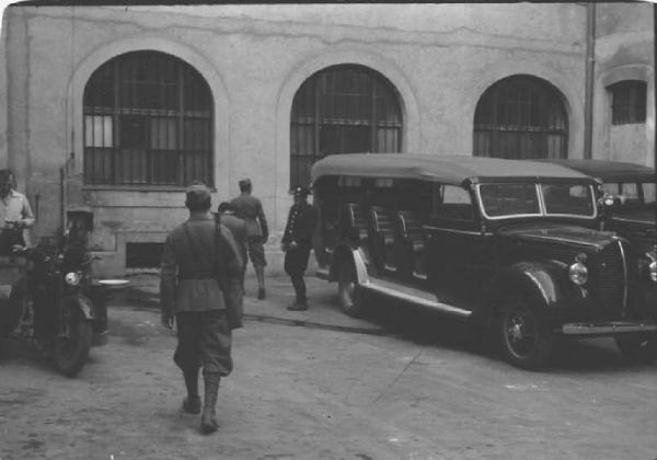 Viaggio in Jugoslavia. Zagabria: il cortile della sede della polizia (?) con miliziani ustascia e un'automobile parcheggiata