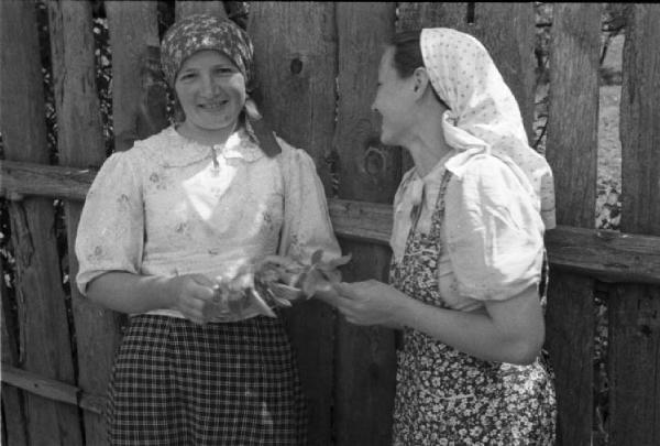 Viaggio in Jugoslavia. Vhrovine: ritratto di coppia, due giovani donne sorridenti presso una staccionata