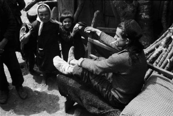 Viaggio in Jugoslavia. Giovane uomo con piede fasciato e bambini sorridenti