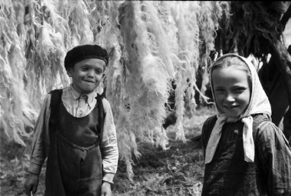 Viaggio in Jugoslavia. Vrhovine: ritratto di coppia, bambini. Alle spalle lana stesa ad asciugare tra gli alberi