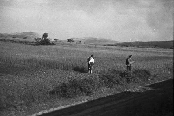 Viaggio in Jugoslavia.  Verso Sebenico: campagna nei pressi di Knin - scorcio del paesaggio dal finestrino del treno con due contadini