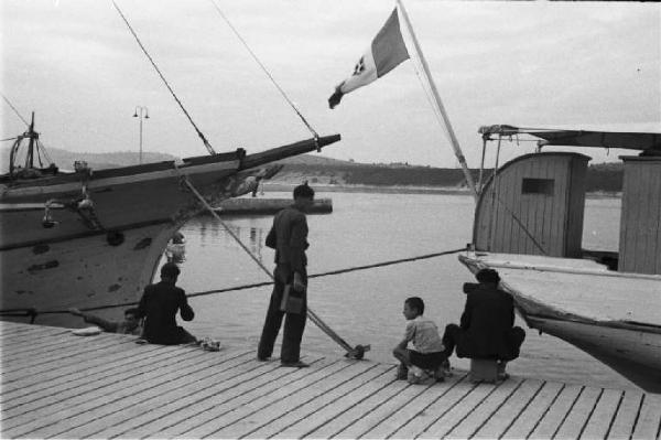 Viaggio in Jugoslavia. Sebenico: scorcio della banchina del porto con un imbarcazione battente bandiera italiana