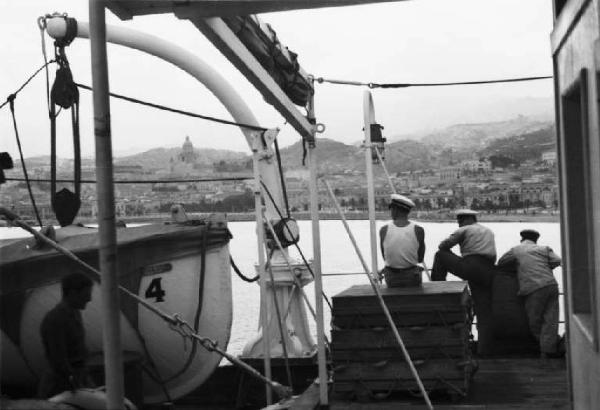 Viaggio in Africa. Viaggio di ritorno in Italia. Partenza da Messina - navigazione nello Stretto - veduta della costa dalla nave con marinai affacciati al parapetto