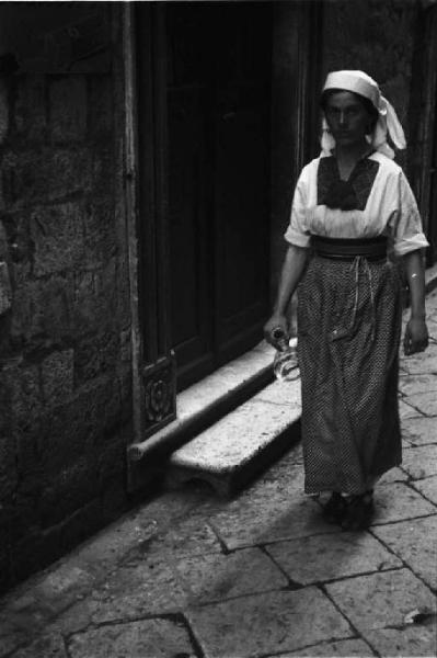 Viaggio in Jugoslavia. Dubrovnik (Ragusa): donna croata in costume locale si aggira per le vie del centro storico