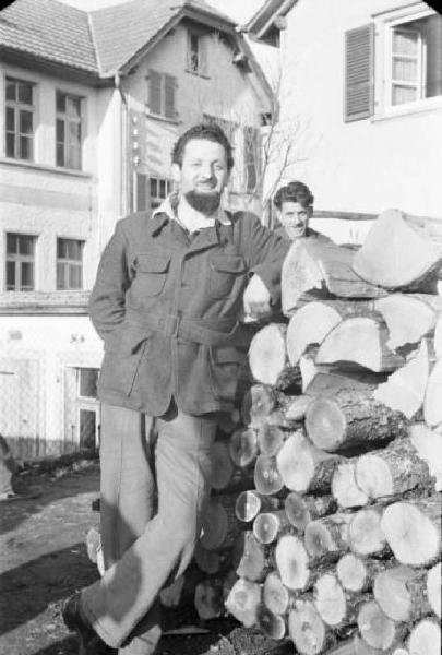 Internamento in Svizzera. Horriwil - Scene di vita quotidiana all'interno del campo, un uomo appoggiato a una catasta di legna