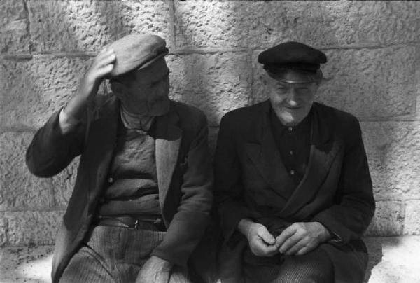 Viaggio in Jugoslavia. Dubrovnik (Ragusa): scene di vita quotidiana - coppia di uomini chiacchierano seduti su una panchina
