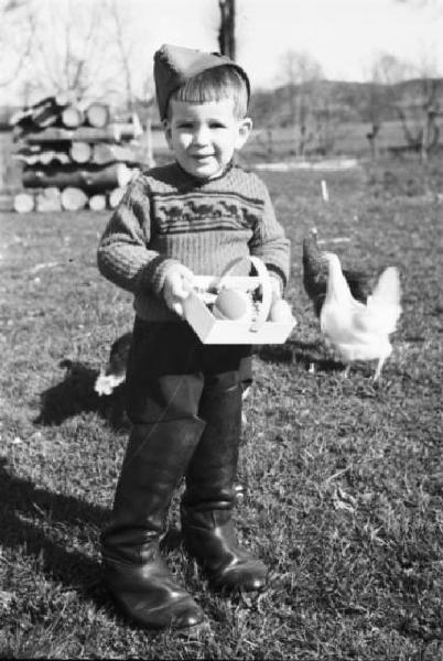 Internamento in Svizzera. Subingen. Famiglia di Don Mangili. Ritratto maschile, bambino con cassettina delle uova di Pasqua in mano