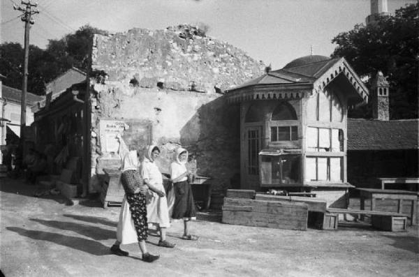 Viaggio in Jugoslavia. Mostar: scene di vita quotidiana - gruppo di donne cammina lungo una strada del paese