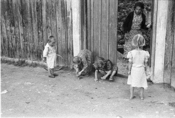 Viaggio in Jugoslavia. Yaitze: un gruppo di bambini gioca ai piedi di una staccionata di legno