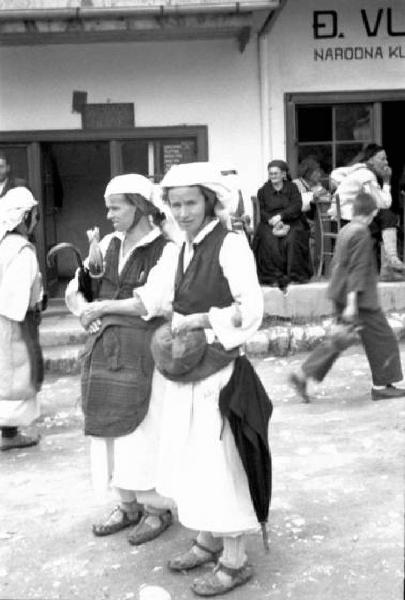 Viaggio in Jugoslavia. Yaitze: coppia di giovani donne bosniache in costume locale in posa nella zona del mercato