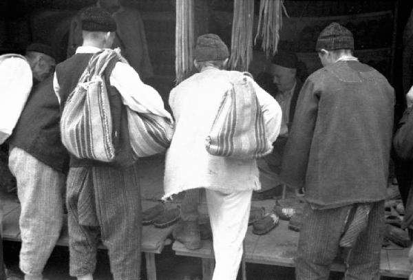Viaggio in Jugoslavia. Yaitze: un gruppo di uomini sosta davanti alla bancarella di un calzolaio