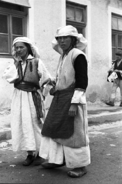 Viaggio in Jugoslavia. Yaitze: coppia di donne bosniache in costume locale a passeggio per le vie della città