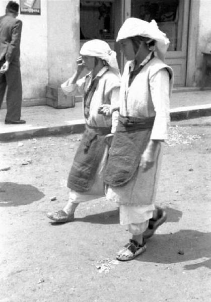 Viaggio in Jugoslavia. Yaitze: coppia di abitanti in costume locale a passeggio per le vie della città