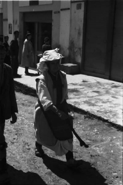 Viaggio in Jugoslavia. Yaitze: anziana donna bosniaca in abiti locali in cammino attorno alla zona del mercato