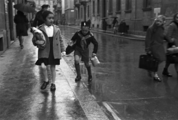 Italia Seconda Guerra Mondiale. Milano - raccolta della lana durante il regime fascista: due giovani studenti durante il tragitto per una via del quartiere portano a mano la busta con la lana