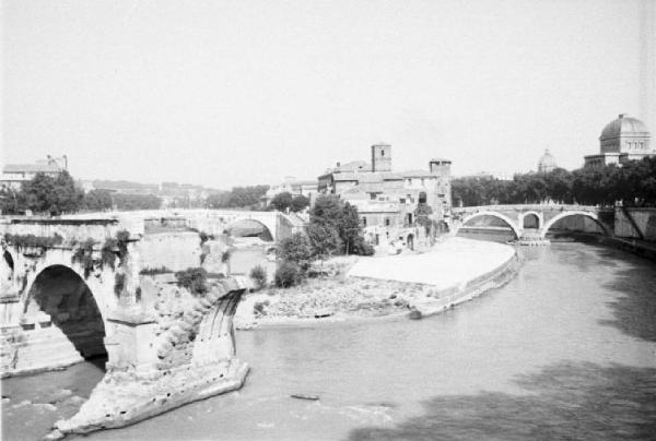 Roma - isola Tiberina. Scorcio dell'isola dal fiume Tevere con i resti di un ponte in primo piano