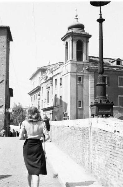 Roma - isola Tiberina. Scorcio dell'isola da uno dei ponti d'accesso con una passante sorpresa di spalle in primo piano