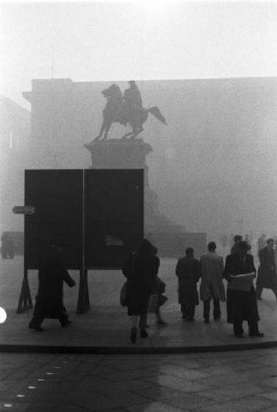 Italia Dopoguerra. Milano - piazza Duomo - Scorcio del cavallo di Garibaldi con alcuni passanti avvolti dalla nebbia