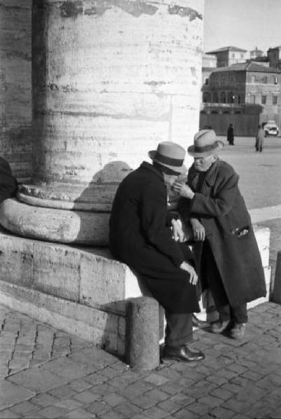 Roma. Scorcio di Piazza San Pietro. Coppia di anziani che chiacchiera ai piedi di una colonna