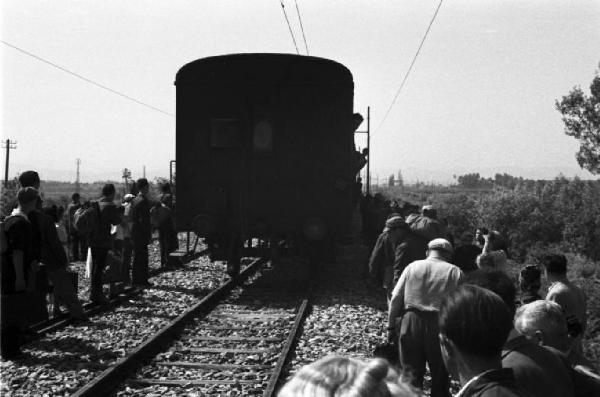 Italia Dopoguerra. Viaggio da Milano a Savona - Passeggeri del treno in attesa lungo i binari presso una carrozza