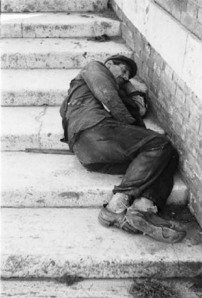 Italia Dopoguerra. Roma - Isola Tiberina - Uomo addormentato sui gradini di una scalinata