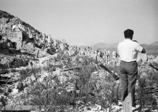 Italia Dopoguerra. Cassino - Un uomo di spalle osserva la città completamente distrutta