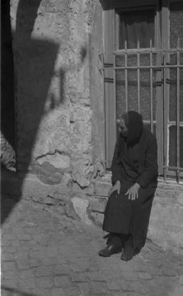 Castel Gandolfo. Scene di vita quotidiana - donna anziana seduta davanti a un'abitazione