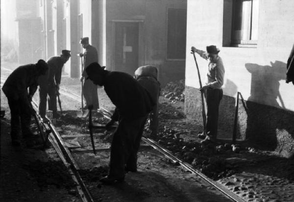 Italia Dopoguerra. Milano - Quartiere Baggio - Gruppo di uomini durante la posa di binari