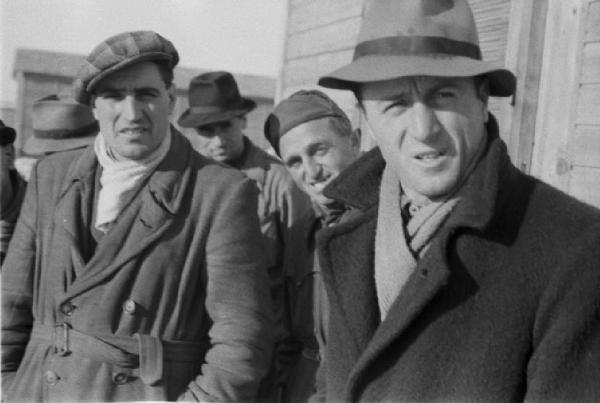 Italia Dopoguerra. Milano - Quartiere Baggio - Ritratto a gruppo di uomini nei pressi degli edifici prefabbricati