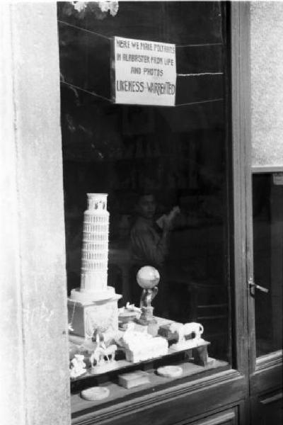 Pisa. Vetrina di un negozio con  torre pendente in miniatura e altri souvenirs - cartello in inglese che reclamizza ritratti su alabastro