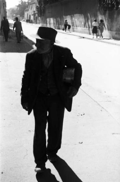Italia Dopoguerra. Milano - Un uomo cammina per strada con la scodella per il cibo sottobraccio