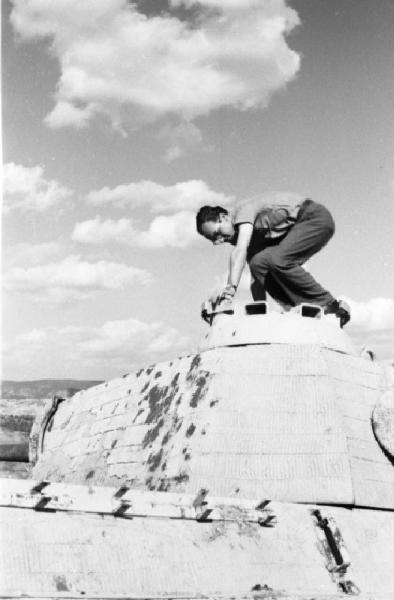 Italia Dopoguerra. Radicofani - Un uomo arrampicato sulla torretta di un carroarmato abbandonato