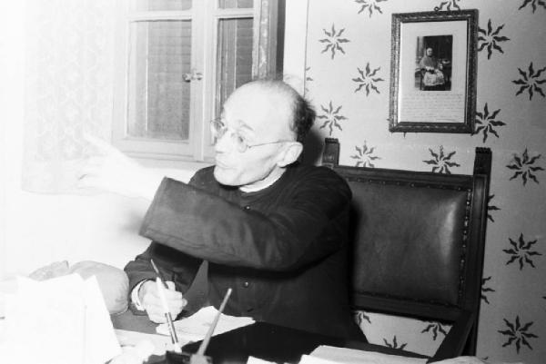Bill e Pedro: ricostruzione dell'uccisione di Benito Mussolini. Dongo - Il reverendo confessore di Claretta Petacci seduto alla scrivania del suo studio